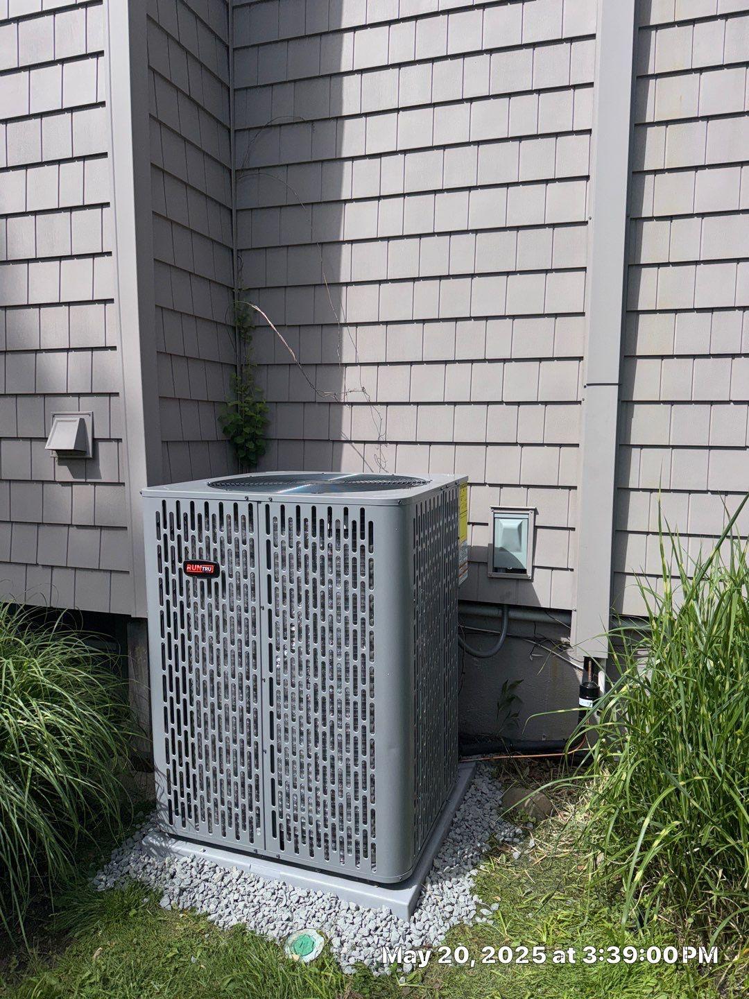 Residential heat-pump outdoor unit installed on a gravel equipment base