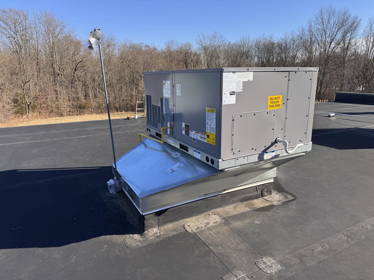 Commercial packaged rooftop HVAC unit installed on a roof curb